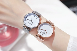 Close-up of minimalist silver and rose gold mesh strap watches on a female wrist