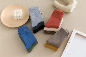Close-up of thick thermal cotton crew socks in vintage colors on a wooden tray