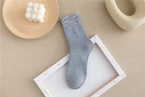 Detail of gray cotton blend thermal socks with ribbed cuffs on a minimalist backdrop
