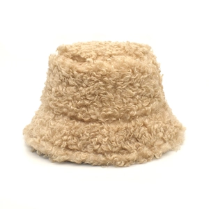Close-up of thick beige faux shearling fabric and texture on winter bucket hat