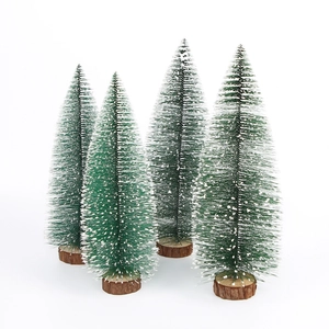 Macro view of four green mini cedar trees with snowy tips and wooden bases