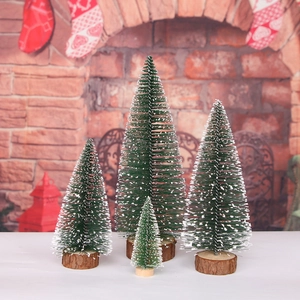 Set of four snowy mini Christmas trees with wooden bases on festive mantel background