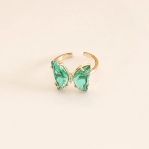 Macro shot of green crystal butterfly wings on an adjustable gold-plated ring