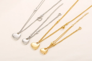 Detail of 18K gold and silver heart pendants with various chain link styles