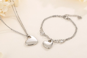 Detailed view of silver heart pendant necklace and bracelet set with double-layer chains