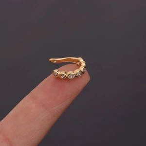 Macro shot of gold U-shaped ear cuff featuring seven sparkling inlaid zircon stones