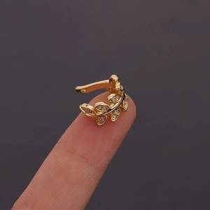 U-shaped gold leaf ear cuff with zircons shown on a finger for size reference