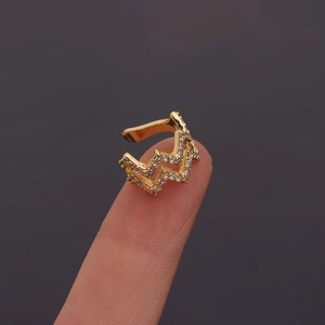 Close-up of golden zigzag ear cuff with sparkling crystals held between fingers