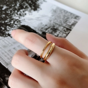 Close-up of a minimalist double-layered gold ring with a polished mirror finish on the finger