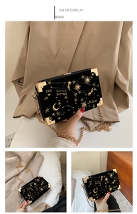 Close-up of black velvet box bag with celestial gold embroidery and metal corners