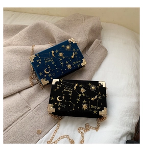 Detail of velvet box bag with gold constellation embroidery and metal chain strap