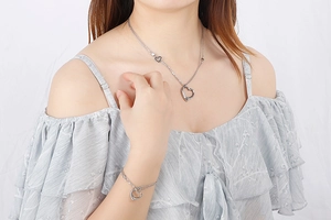 Close-up of silver stainless steel hollow heart pendant necklace and bracelet set
