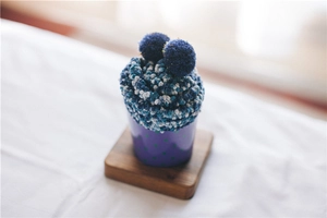 Detail showing plush coral fleece socks shaped like a cupcake in a decorative cup