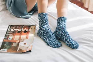 Close-up of thick coral fleece blue and white knit socks for home comfort and warmth