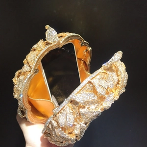 Détail intérieur d'un sac de soirée doré montrant la grande capacité pour téléphone