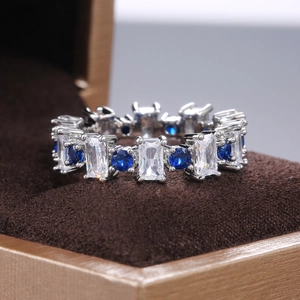 Bague éternité avec zircons carrés et pierres bleues sertis sur métal argenté