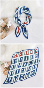 Detailed view of pleated silk scarf with blue geometric patterns and abstract art prints
