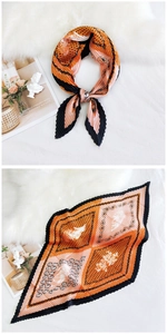 Detailed view of pleated silk scarf featuring paisley patterns and geometric orange blocks