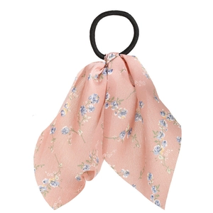 Detail view of pink floral ribbon hair tie with silky satin texture and elastic band