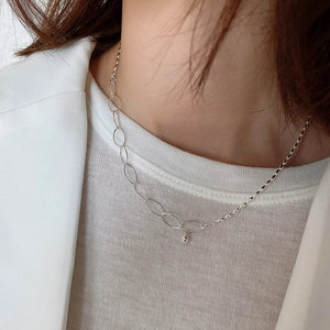 Detail of 925 sterling silver olive bead necklace worn on a white suit model