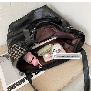 Spacious interior of black rivet tote bag showing storage for umbrella and books