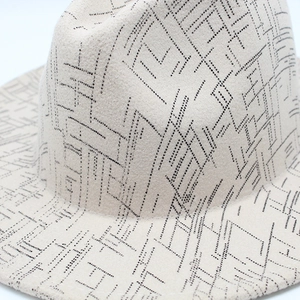 Detailed view of beige wool felt fedora featuring black dot geometric pattern texture