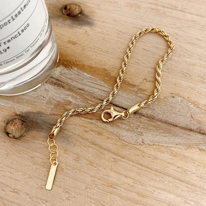 Minimalist 925 sterling silver rope chain bracelet with gold plating on light wood