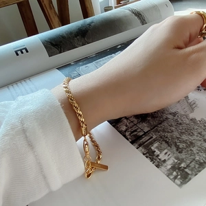 Close-up of S925 sterling silver gold-plated twisted rope chain bracelet and ring