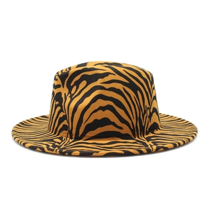 Detail shot of a wide-brim fedora hat featuring orange and black tiger stripe patterns