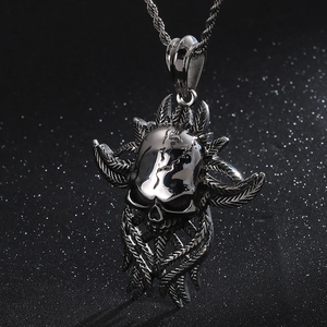 Macro detail of gothic skull pendant with feather carvings on a silver metal chain