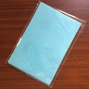 Detail view of 100 sheets light blue A5 tissue paper pack on dark wood background