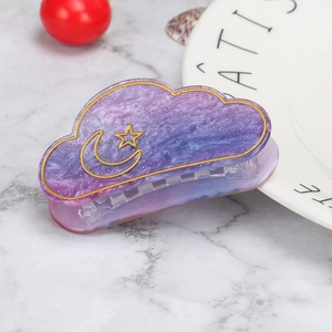 Detail of purple gradient cloud hair claw clip with golden moon and star patterns