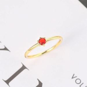 Classic six-prong solitaire ring with a bright red gemstone on a slim gold band