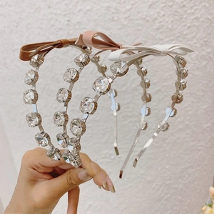 Detail of crystal headband with shiny rhinestones and elegant ribbon bows in three colors