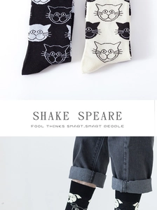 Detail of cartoon cat and dog embroidered patterns on cotton crew socks in black and cream