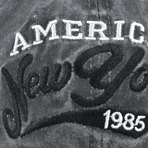 Macro shot of 1985 New York embroidery on washed cotton baseball cap texture