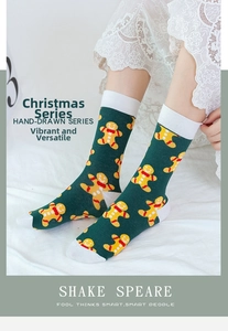 Close-up of green Christmas socks with gingerbread man patterns on white lace background