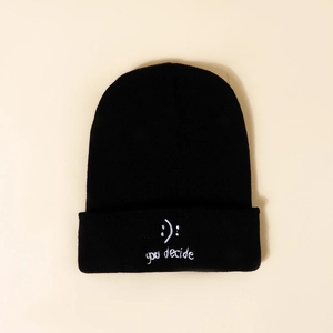 Detail of white embroidery with 'you decide' phrase on black knitted beanie hat