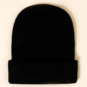 Detail of black cuffed beanie showing thick knit texture and minimalist winter design