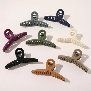 Flat lay of large matte shark hair claws in eight assorted elegant colors for styling