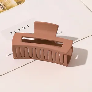 Close-up of a large matte brown hair claw clip with a hollow rectangular design for styling