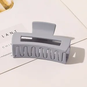 Detail view of large matte grey square hair claw clip on minimalist background
