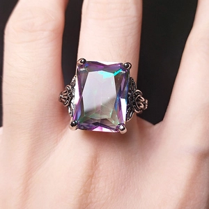 Macro shot of rectangular rainbow topaz ring with silver hollow filigree detailing