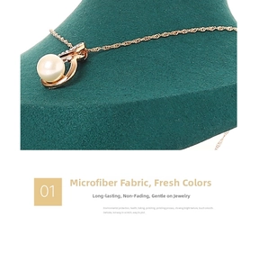 Close-up of rose gold pearl necklace on dark green microfiber jewelry bust stand