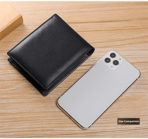 Size comparison of a black leather trifold wallet next to a smartphone on a wooden desk