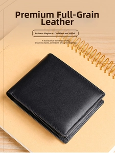 Close-up of black top grain leather trifold wallet on a notebook showing fine texture
