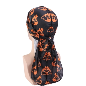 Detail of black silk durag featuring orange fox pattern and long tail design on mannequin