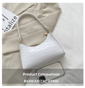 Detail view of white crocodile pattern shoulder bag with elegant gold hardware accents