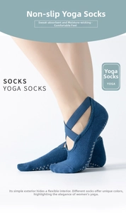 Detail of dark blue yoga socks with elastic cross straps and gray anti-slip grip dots
