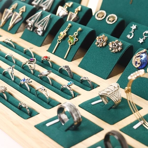 Bamboo and velvet jewelry display tray with assorted gold rings and gemstone earrings